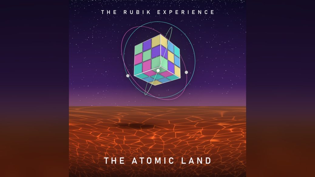 Copertina di The Atomic Land di The Rubik Experience: un cubo di Rubik con anelli atomici sospeso su una terra rossa sotto un cielo stellato
